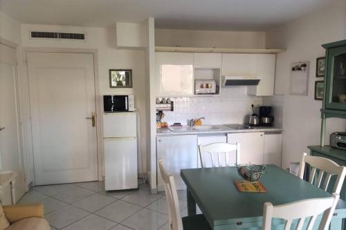 une cuisine avec une table et des chaises et une table et une cuisine dans l'établissement Havre de paix en plein centre ville, 4 couchages, à Menton