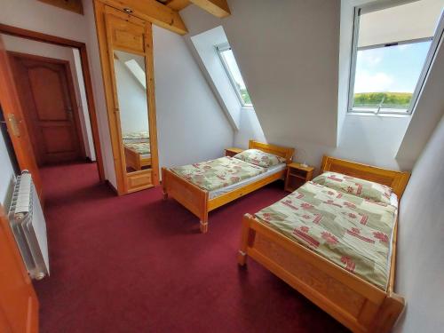 a small room with two beds and a mirror at Holiday Raj in Bešeňová