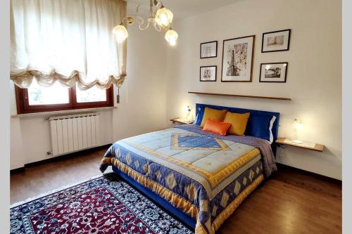 sypialnia z niebieskim łóżkiem i oknem w obiekcie Diamante: Appartamento nel cuore della Toscana w mieście Castelfranco di Sotto