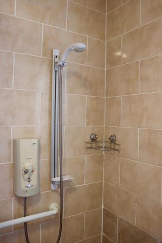 a shower with a shower head in a bathroom at EXQUISITE FOLK VICTORIAN ONE-BED HOUSE: in Leeds