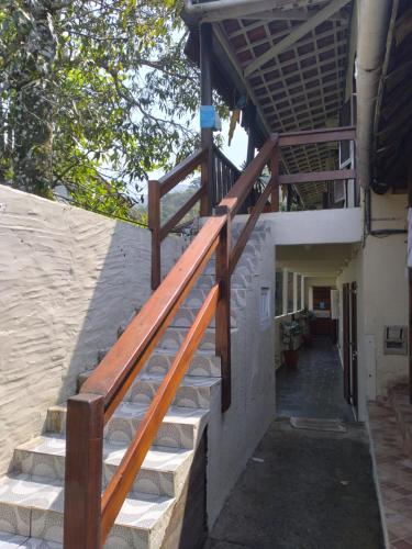 a stairway leading up to a building with a wooden railing at Pousada Marimbá in Trindade