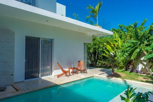 a villa with a swimming pool and two chairs at Villa Calma, Chic & Mexican Villa, a True Oasis Pool, Security in Tulum