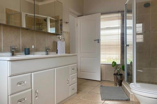 a bathroom with a sink and a toilet and a shower at Odenvillea House - Amazing Sea Views in Durban