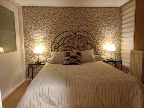 - une chambre avec un grand lit et deux lampes dans l'établissement Apartamento Turístico Santiago, à Logroño