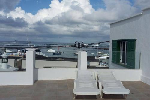 オルソラにあるApartamentos Los Vientos (Apto 8)の水辺の景色を望むバルコニー(白い椅子付)