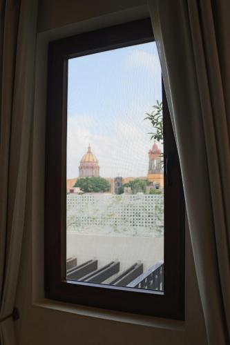 a window in a room with a view of a city at Cantera 1910 Hotel Boutique, Destination Hotel in San Miguel de Allende