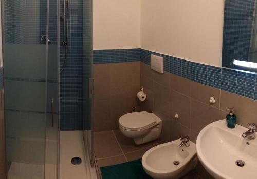 a bathroom with a toilet and a shower and a sink at Josso House in Sorso