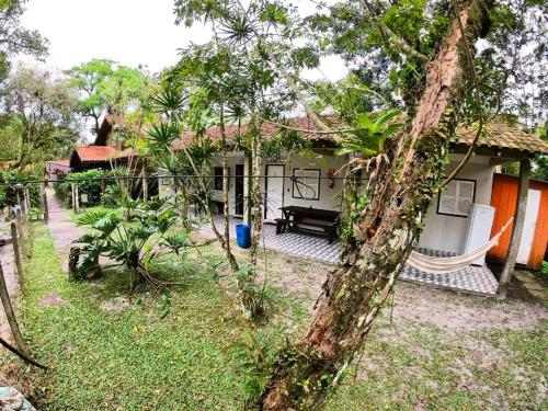 a house with a hammock in front of it at Pousada Recanto da Gruta in Ilha do Mel