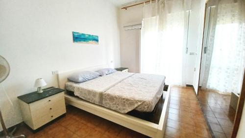 Luni的住宿－appartamento mare di Luni Mare，一间卧室配有床、床头柜和窗户