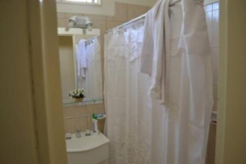 a bathroom with a white shower curtain and a sink at Mendoza departamento Chile 1358 in Mendoza