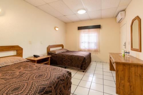 Cette chambre comprend 2 lits et un lavabo. dans l'établissement Hotel Sntenario, à Chihuahua