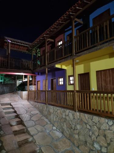 a building with a stone walkway at night at Pousada Cachoeiras de Milho Verde in Milho Verde