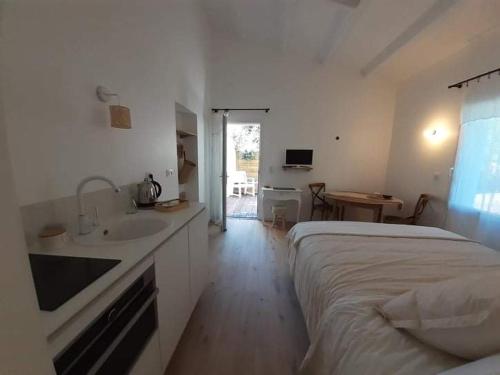 a white bedroom with a bed and a sink at Chambre Cosy Chic in Challans