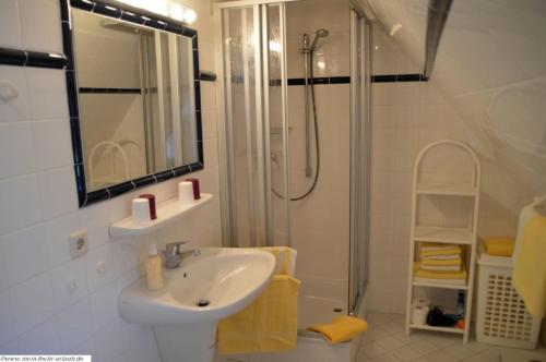 La salle de bains blanche est pourvue d'un lavabo et d'une douche. dans l'établissement Luv - a05408, à Dunsum