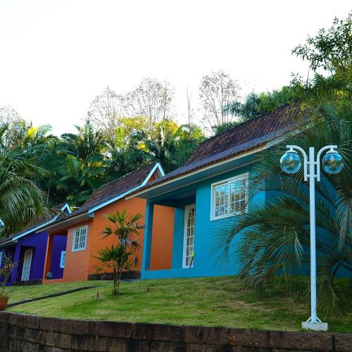 a colorful house with a cross in front of it at Pousada Vale Dos Figos in Urussanga