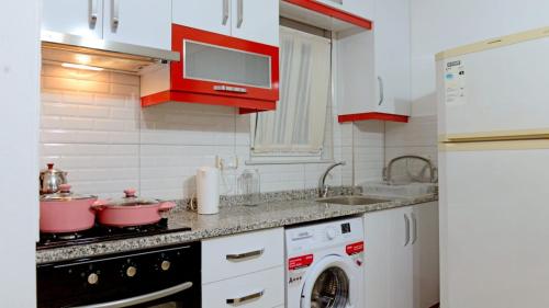 a kitchen with a stove and a washing machine at can apart hotel in Kemer