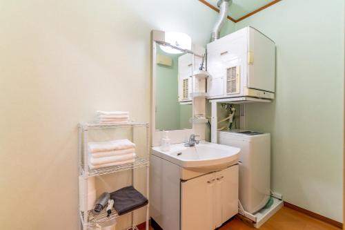 un piccolo bagno con lavandino e specchio di Type D Room 35平米 -ウル エスポワール石垣- a Isola di Ishigaki