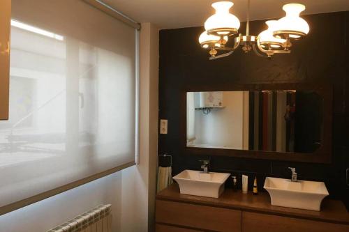 a bathroom with two sinks and a large mirror at Loft de diseño con garaje in Santander