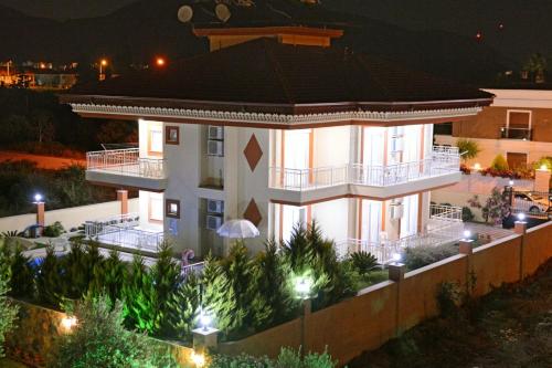a large house with a balcony at night at can apart hotel in Kemer
