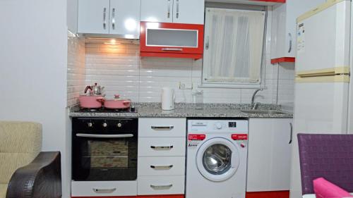 a kitchen with a stove and a washing machine at can apart hotel in Kemer