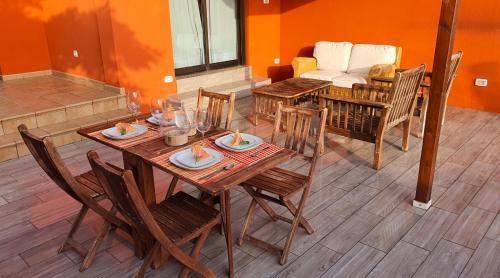 a dining room with a table and chairs and a couch at Romántico apartamento, piscina y BBQ en Playa La Tejita in El Médano