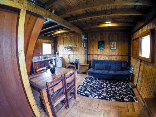 a living room with a blue couch and a table at Hotel Guerra - Pousada Montebelo in Jaguaruna
