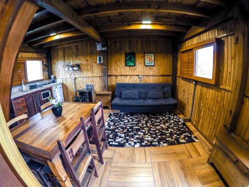 a wooden room with a table and a couch in it at Hotel Guerra - Pousada Montebelo in Jaguaruna