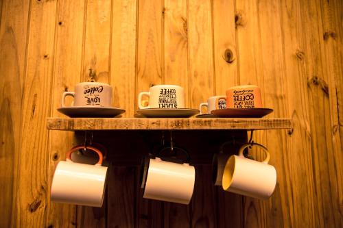 a shelf with three coffee cups and saucers at Hotel Guerra - Pousada Montebelo in Jaguaruna