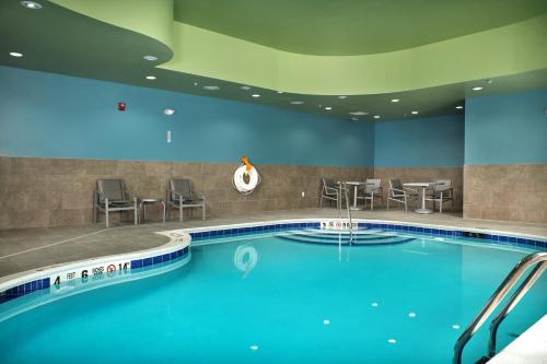 a pool in a hotel with chairs and tables at Holiday Inn Express - Lockport by IHG in Lockport