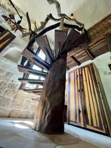a tree sculpture in a room with a staircase at Sueños Tulum in Tulum