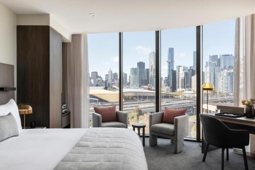 メルボルンにあるOakwood Premier Melbourneのベッド付きのホテルルームで、市街の景色を望めます。