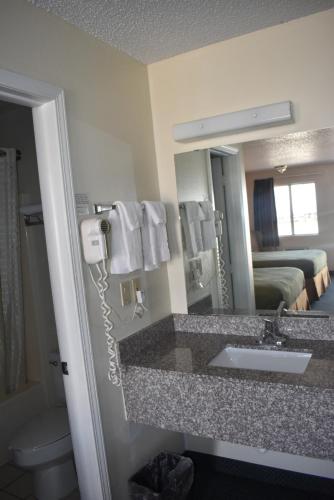a hotel bathroom with a sink and a mirror at Royal Inn in Springdale