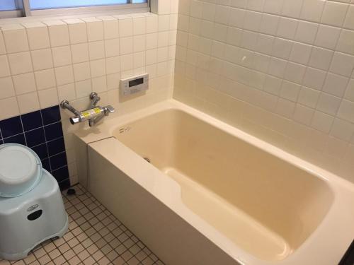 a white bath tub in a bathroom with a toilet at すさのわ in Izumo