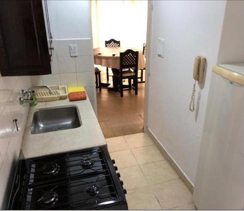 een keuken met een wastafel en een keuken met een tafel bij Depto Temporario Entre Rios 729 in Salta