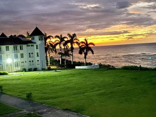 una casa en la playa con palmeras y el océano en C'DaView Apartment Suite, en Montego Bay