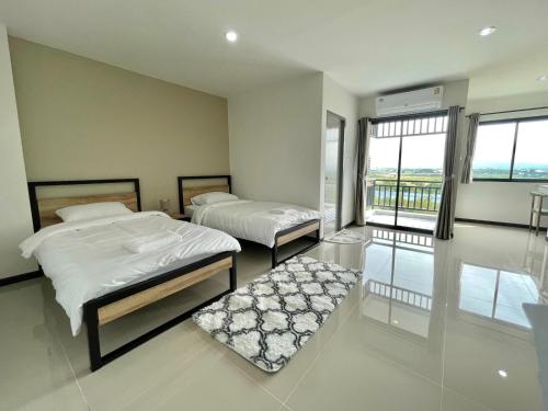 a bedroom with two beds and a balcony at Siri Residence Bowin in Ban Phan Sadet Nai