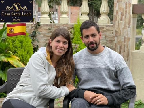 a man and a woman sitting on a bench at Hotel Casa Santa Lucía in Baños