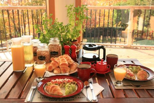 The Burgundy Dream Bed And Breakfast في Fall River: طاولة مع وجبة إفطار من الكرواسون وعصير البرتقال