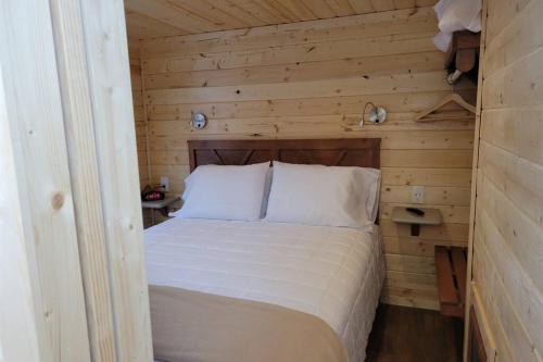 ein Schlafzimmer mit einem Bett in einer Holzhütte in der Unterkunft 076 Tiny Home nr Grand Canyon South Rim Sleeps 8 in Valle