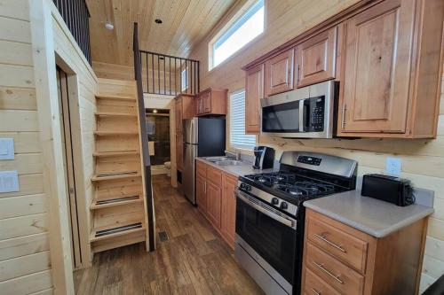 a kitchen with a stove and a microwave at 077 Tiny Home nr Grand Canyon South Rim Sleeps 8 in Valle
