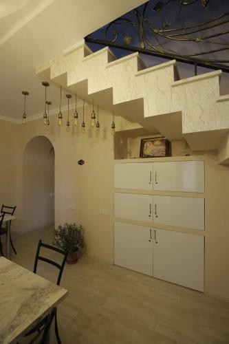 a living room with a staircase with a dresser at HOTEL COMFORT in Kutaisi