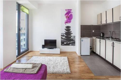 a living room with a purple couch and a kitchen at Modern Living Apartments in Skopje