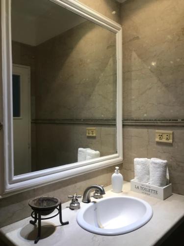 La salle de bains est pourvue d'un lavabo et d'un grand miroir. dans l'établissement Casa de Piedra- céntrica, à La Rioja