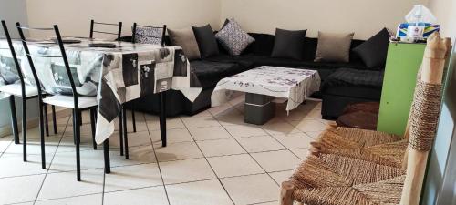 un soggiorno con divano nero e tavolo di Bright whole apartment 500 meters from the center Air conditioner available in each room a Marrakech