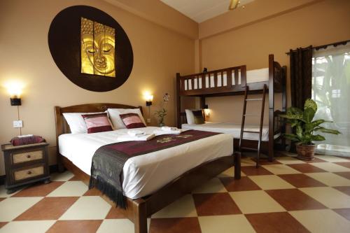 een slaapkamer met een bed en een stapelbed bij Liam's Guesthouse Adults Only in Chiang Mai