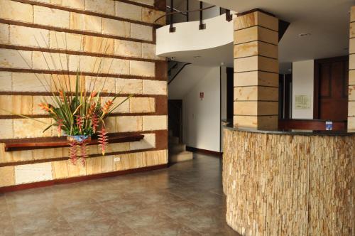 a lobby with a wooden wall and a plant at Hotel AW Boutique in Bogotá