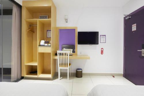 a room with a desk with a chair and a tv at East Sun Hotel Sekinchan Self Check In in Sekincan
