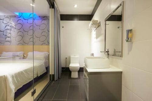 a bathroom with a bed and a sink and a toilet at East Sun Hotel Sekinchan Self Check In in Sekincan