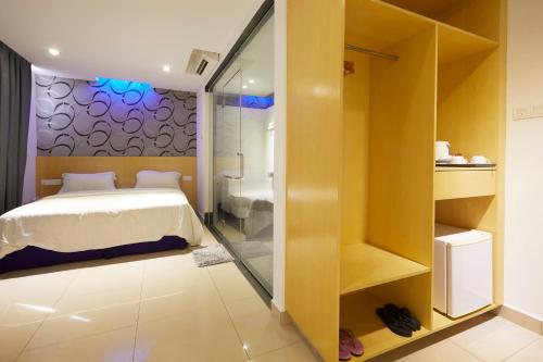 a bedroom with a bed and a glass shower at East Sun Hotel Sekinchan Self Check In in Sekincan
