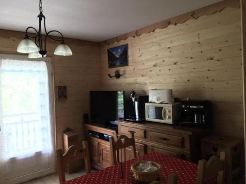 - une cuisine avec une table et un four micro-ondes dans l'établissement Appartement 6 pers. avec terrasse - 3 Pièces 6 personnes MAE-9108, à Cauterets